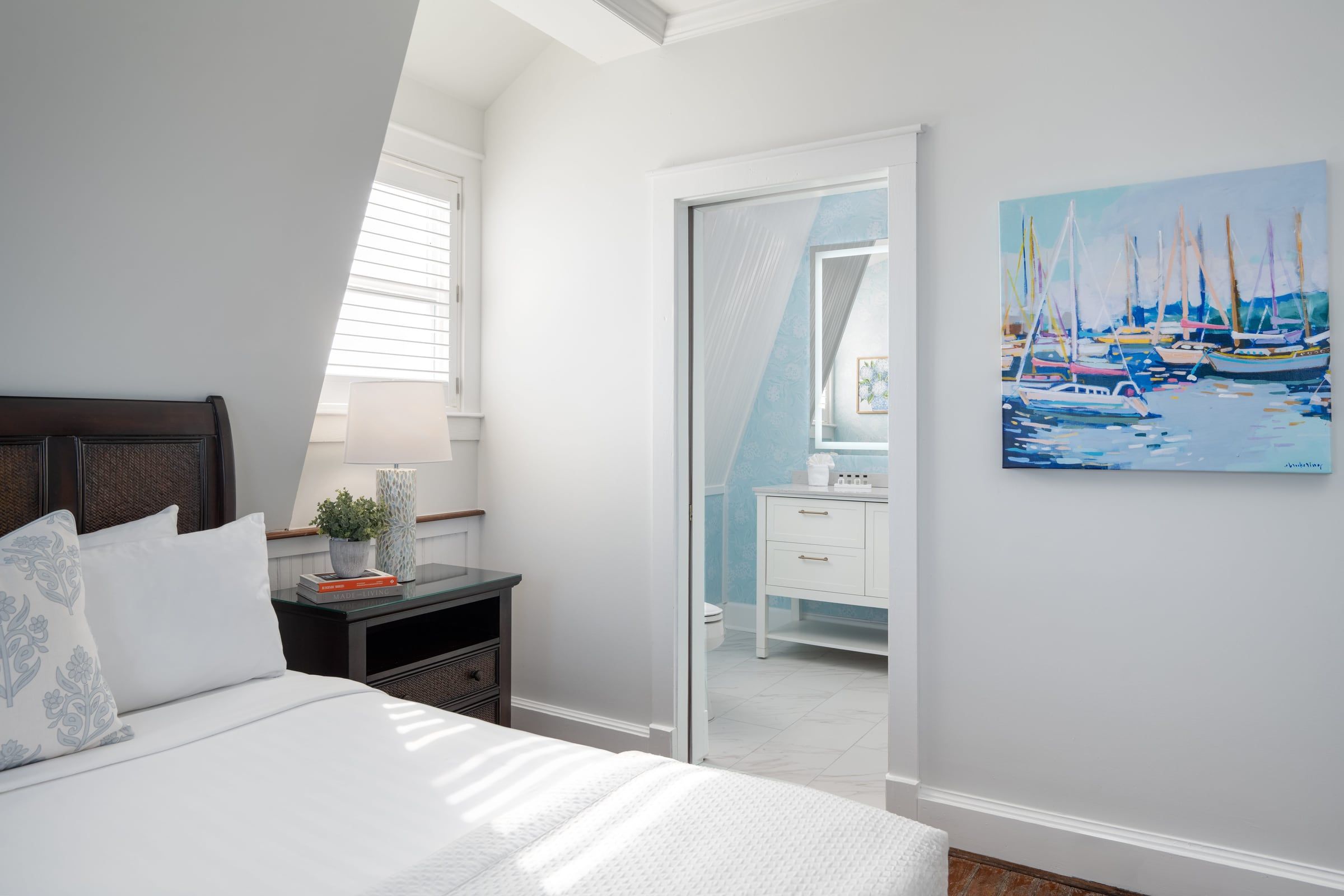 Elizabeth Pointe guest room with white bedding and a sailboat painting
