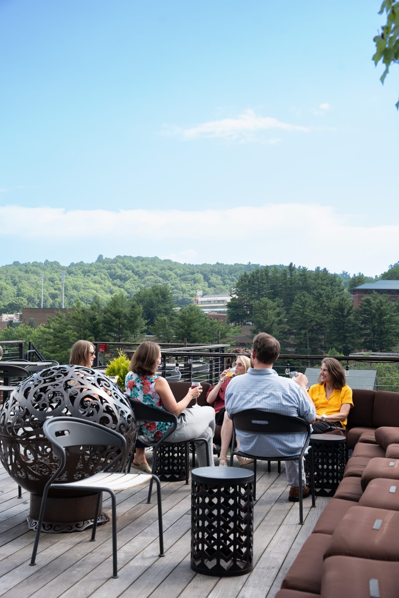 Guests gathered around fire tables on The Horton Hotel rooftop, overlooking the Boone mountains
