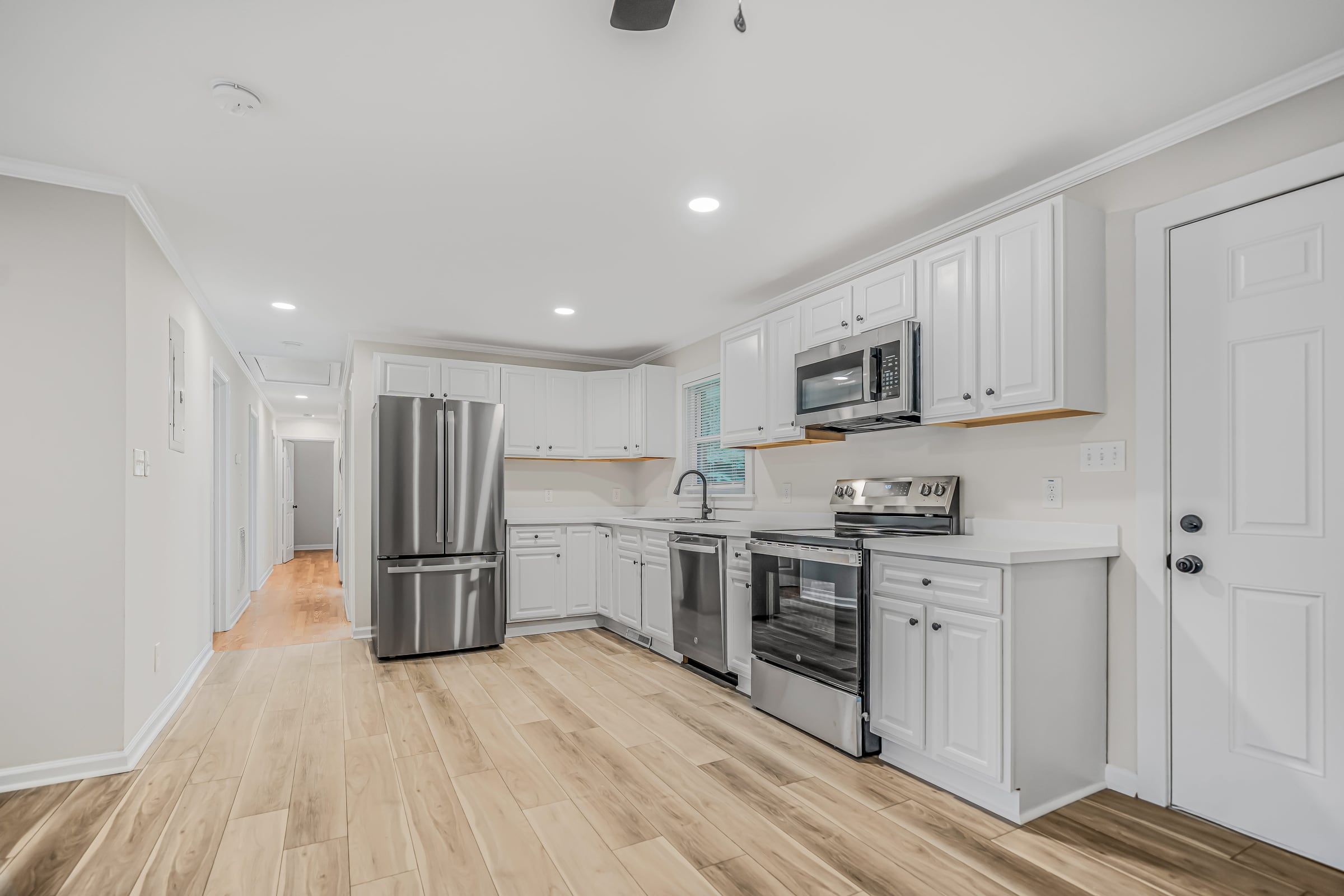 Renovated kitchen at The Ramsey with white cabinets and stainless appliances